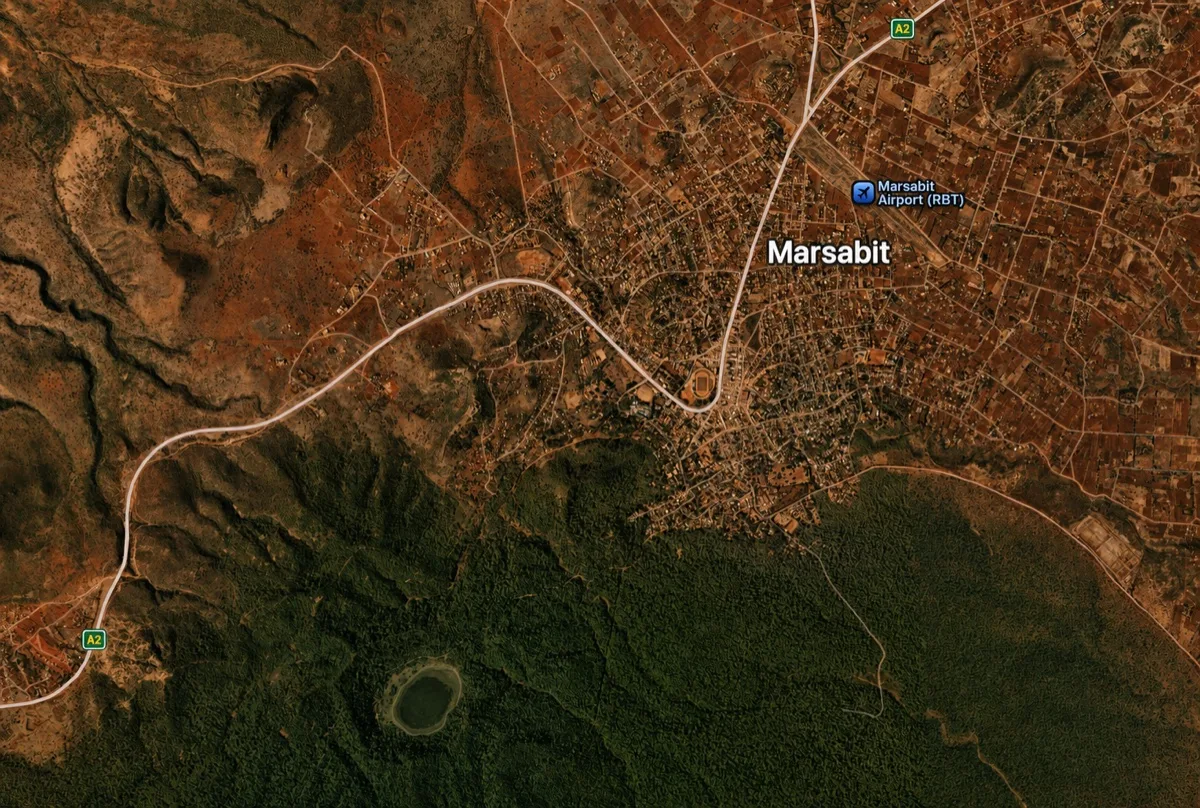 Warm-toned satellite view of Marsabit showing terrain, forest, roads, the airport, and the town